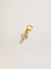 Key-shaped charm in gold-colored brass with crystals