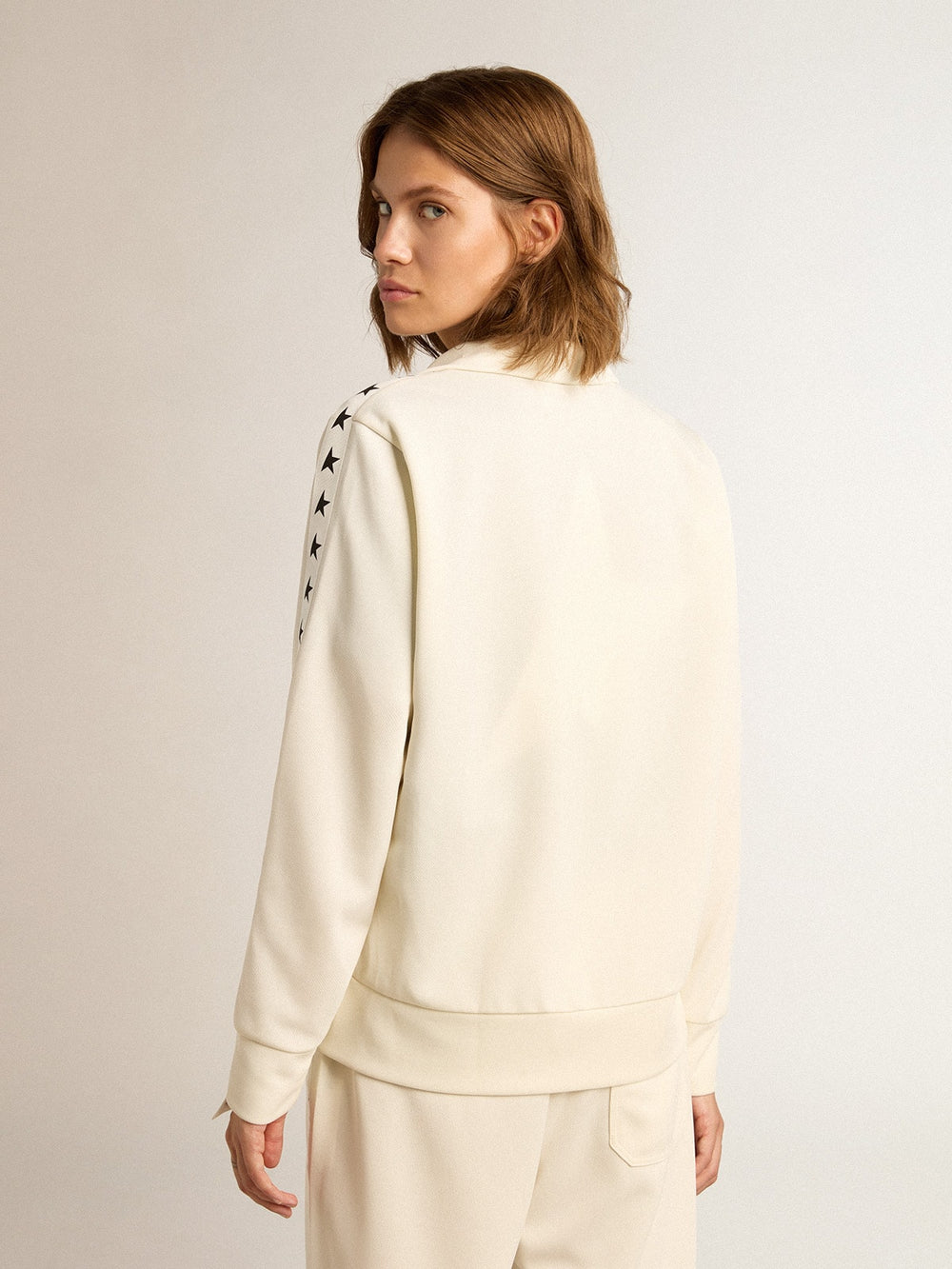 Women’s white zipped sweatshirt with white strip and black stars