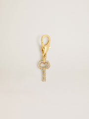 Key-shaped charm in gold-colored brass with crystals