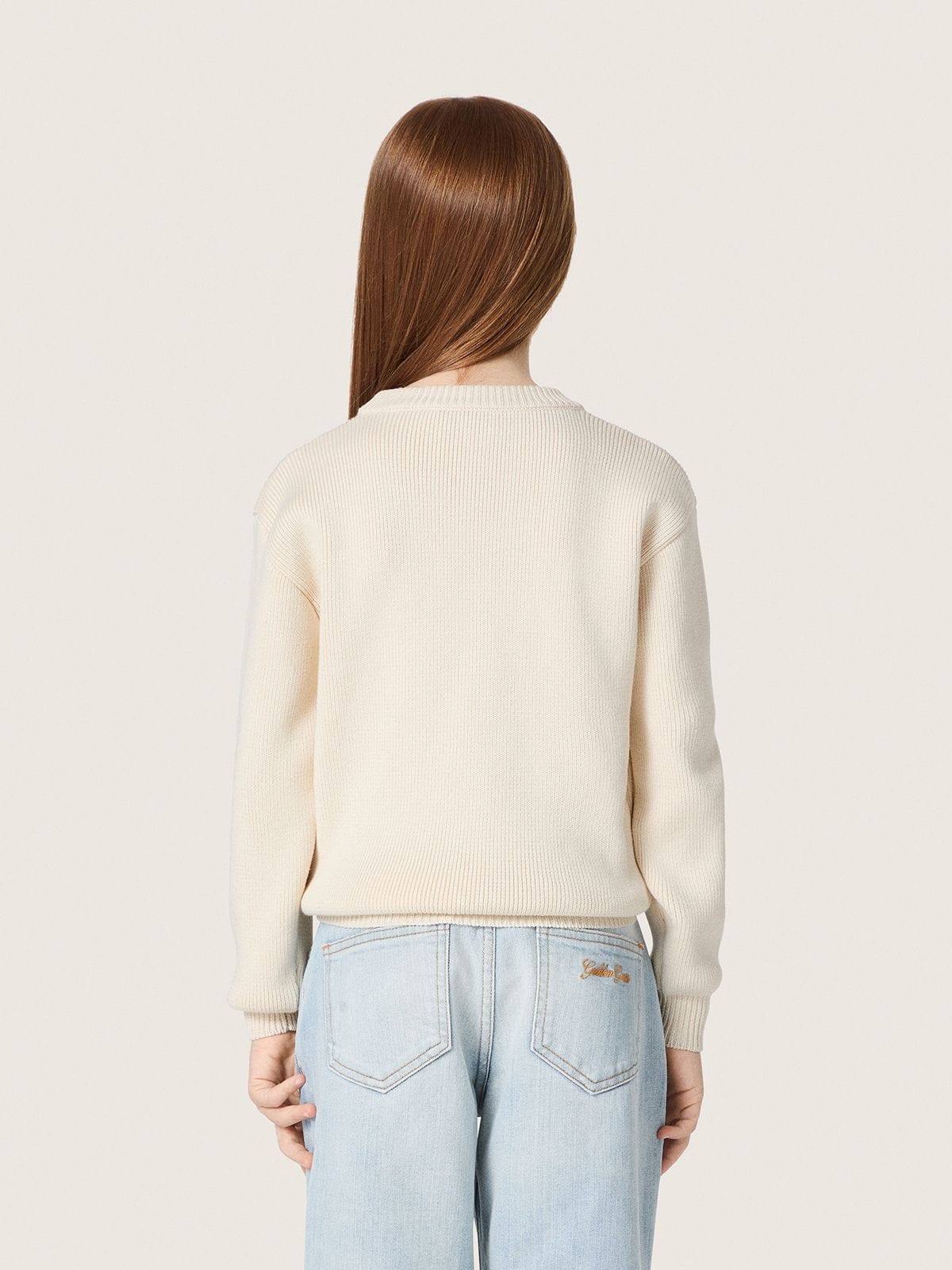 Golden girls’ sweater in white cotton yarn with mascot embroidery