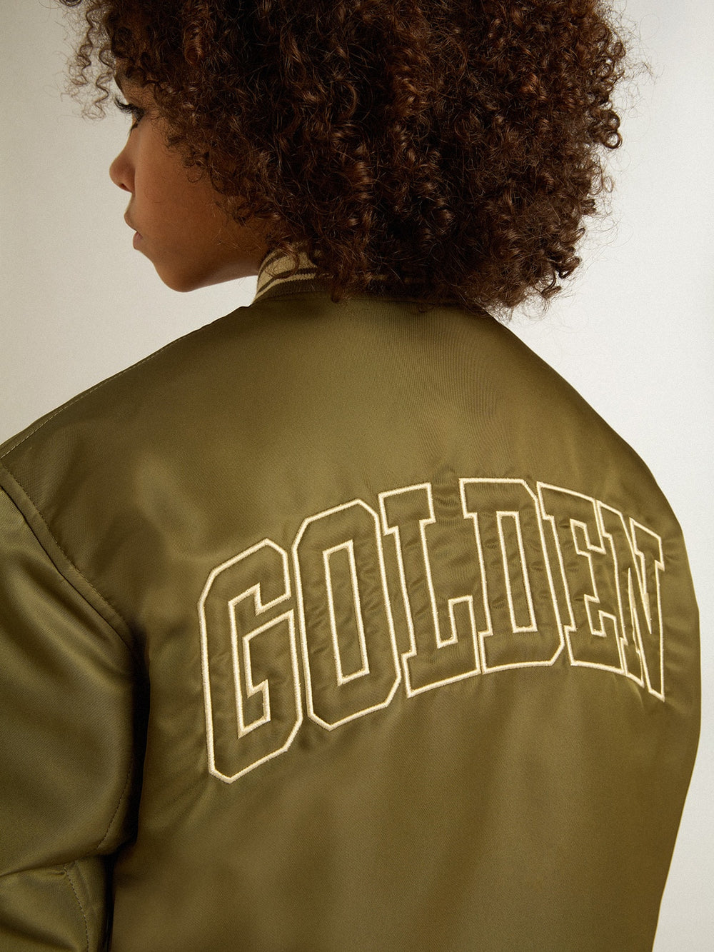 Kids military-green nylon bomber jacket with lettering on the back